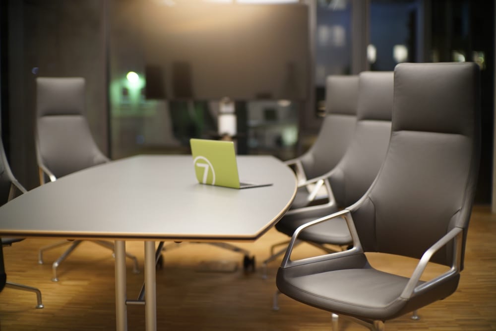 Conference room in virtual7's Karlsruhe office with a large table, modern chairs, and a laptop with the virtual7 logo.