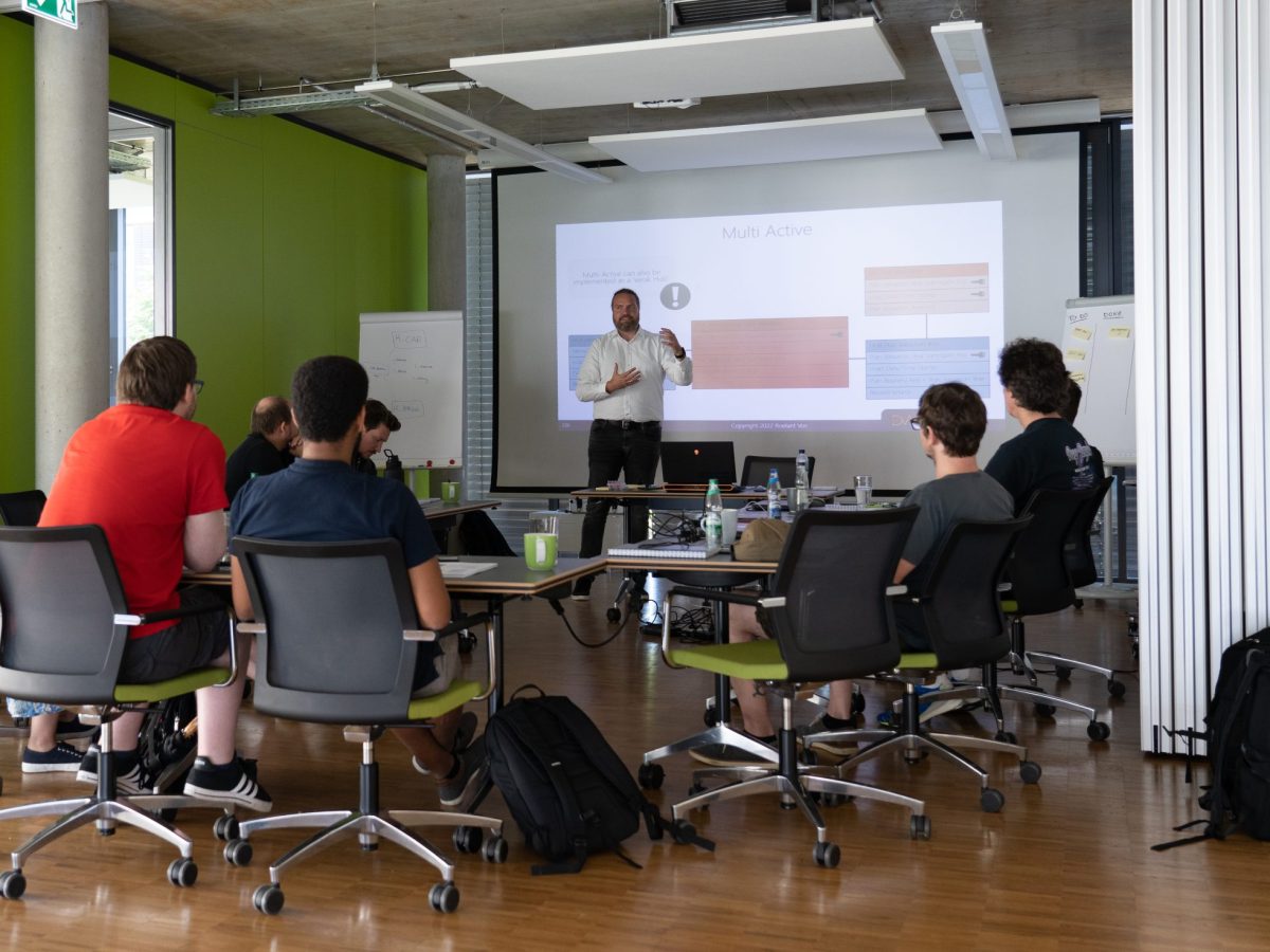Roelant Vos holds a training session in front of a group of employees in a modern seminar room.