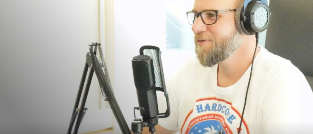 Mitarbeiter von virtual7 mit Kopfhörern vor einem Mikrofon während einer Podcast-Aufnahme.