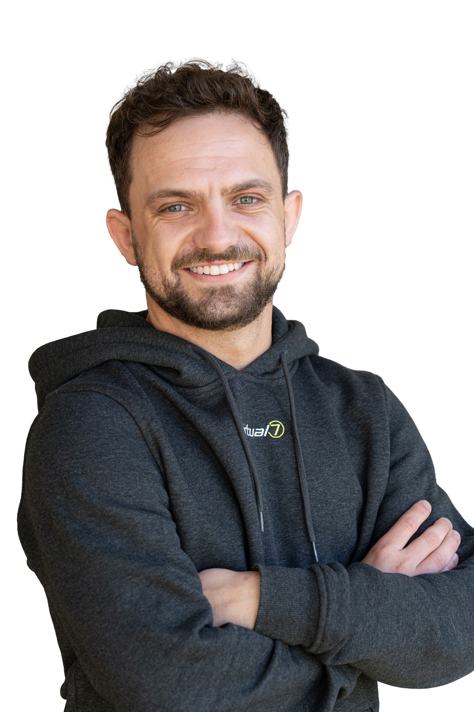 Porträt von Fabian Herdle im dunkelgrauen virtual7-Hoodie vor grünem Hintergrund, mit verschränkten Armen und freundlichem Lächeln.