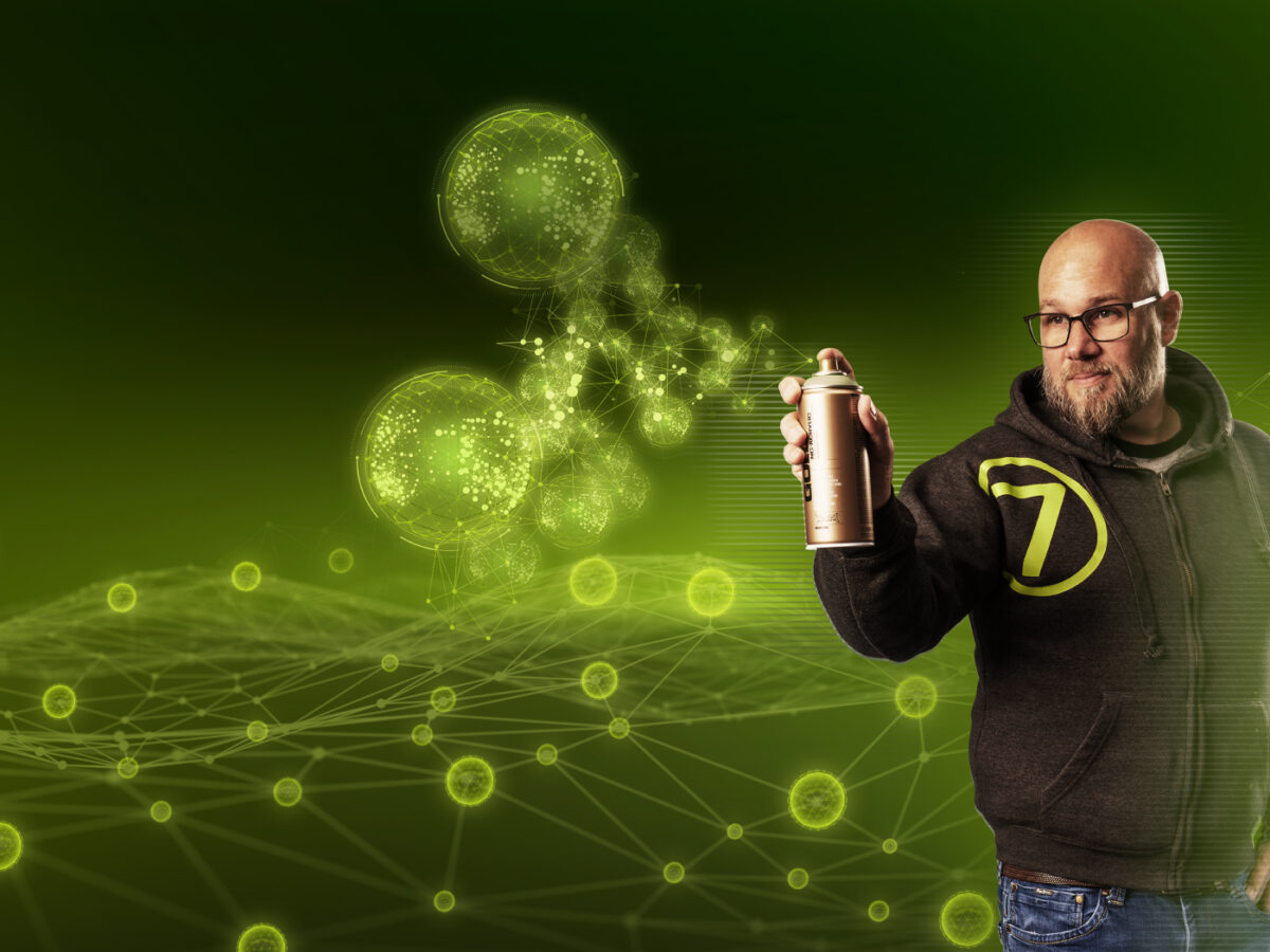 Mitarbeiter von virtual7 mit Brille und Hoodie, hält eine Sprühdose vor digitalem, grün leuchtendem Netzwerk-Hintergrund.