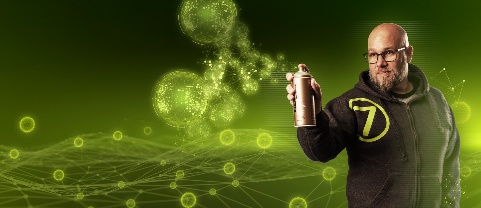 Mitarbeiter von virtual7 mit Brille und Hoodie, hält eine Sprühdose vor digitalem, grün leuchtendem Netzwerk-Hintergrund.