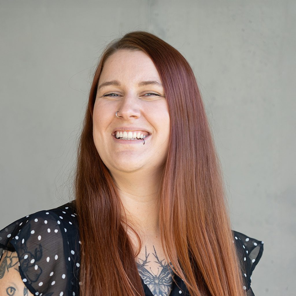 Porträt einer Mitarbeiterin aus dem Recruiting-Team von virtual7, lächelnd vor hellem Hintergrund.