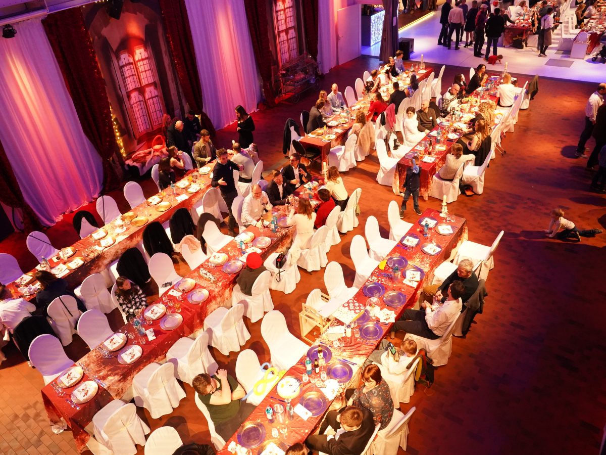 Feierlich gedeckte Tische mit vielen Gästen auf der virtual7 Weihnachtsfeier 2024