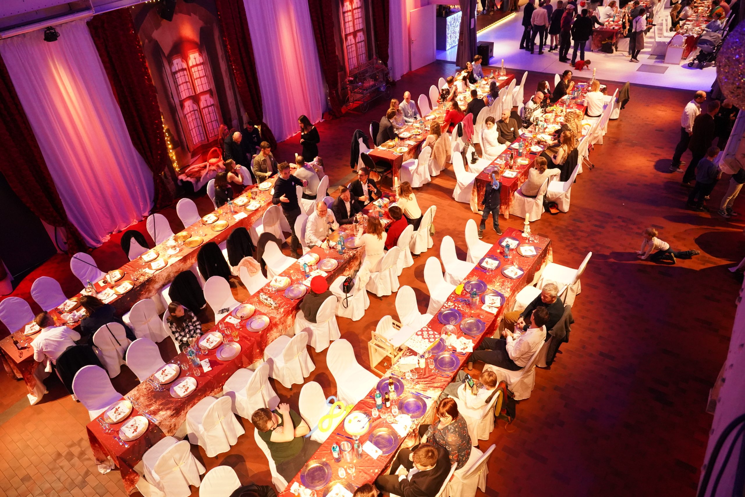 Feierlich gedeckte Tische mit vielen Gästen auf der virtual7 Weihnachtsfeier 2024