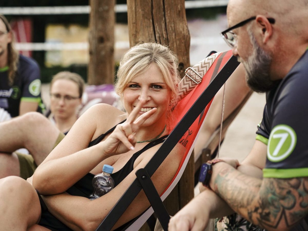 Mitarbeitende von virtual7 entspannen während der conference 2025, eine Frau lächelt in die Kamera und zeigt das Peace-Zeichen.