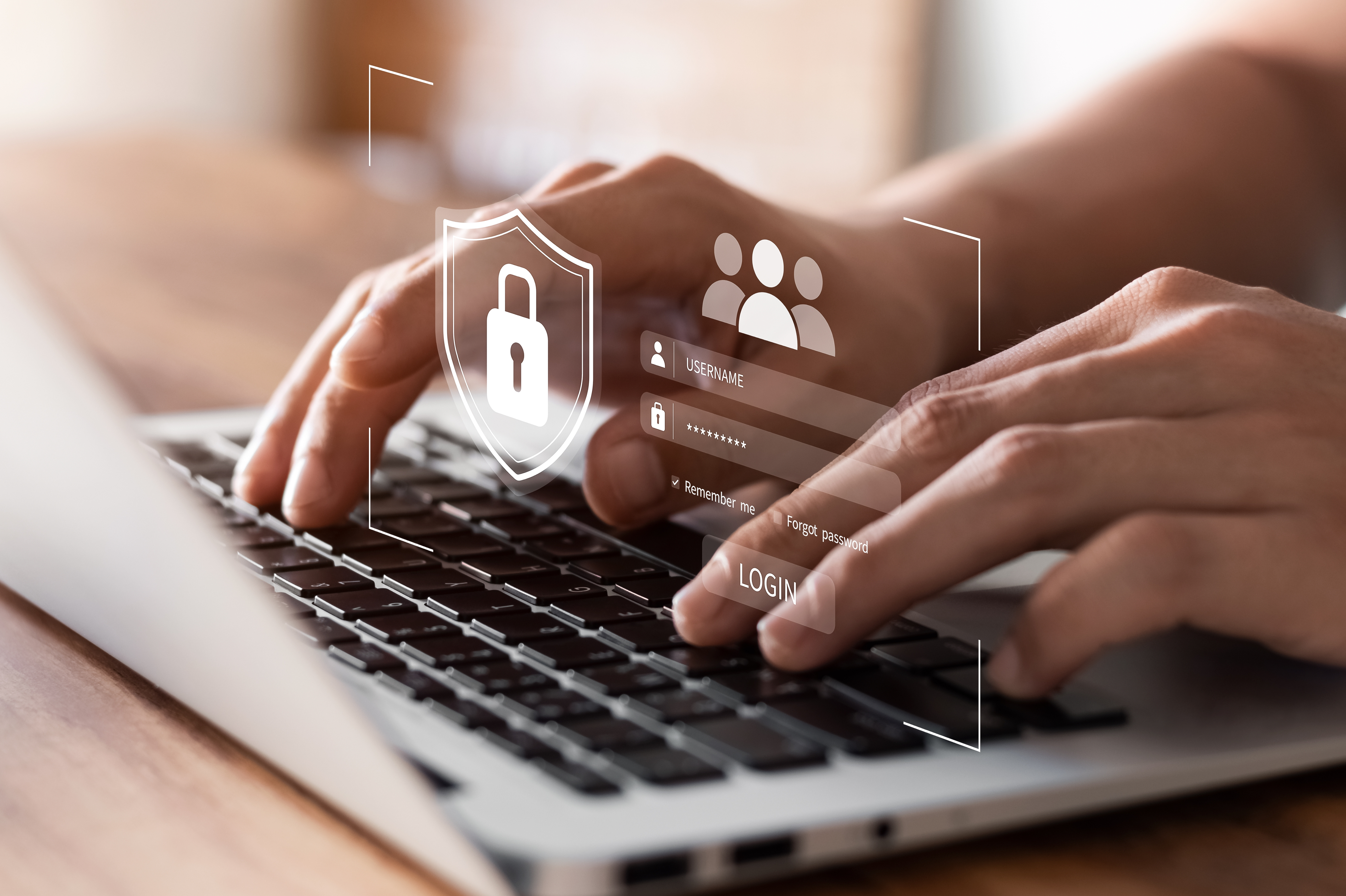 Finger, die auf einem Laptop tippen mit eingeblendeten Symbolen zu Login und IT-Sicherheit